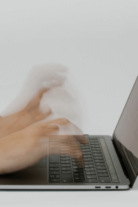 person typing fast on a laptop