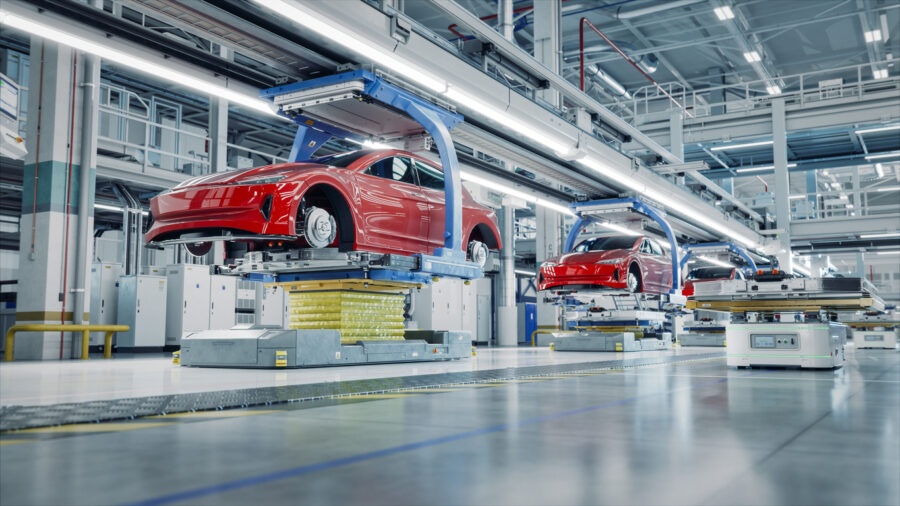 EV Production Line on Advanced Automated Smart Factory. High Performance Electric Car Manufacturing. Car Batteries being Attached to Electric Vehicles on Assembly line. AGV Transport Batteries.